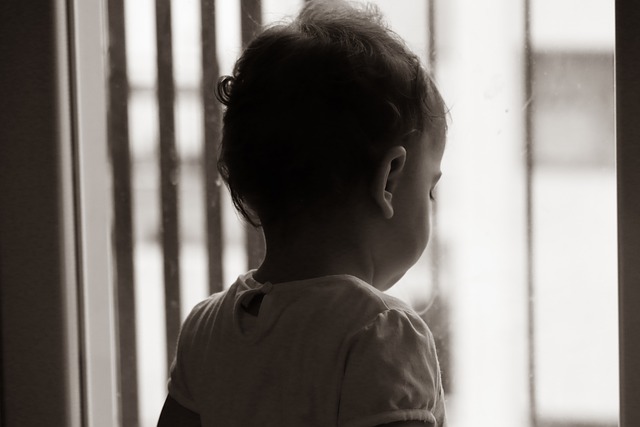 dítě stojí u okna